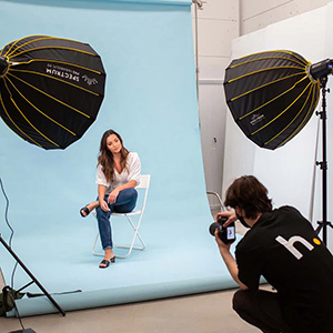 man taking a photo of a woman in a photo studio